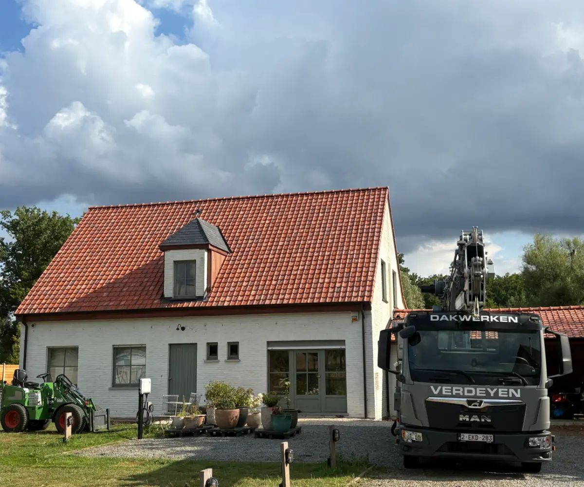 Kraanwagen van Dakwerken Verdeyen bij een gerenoveerd dak